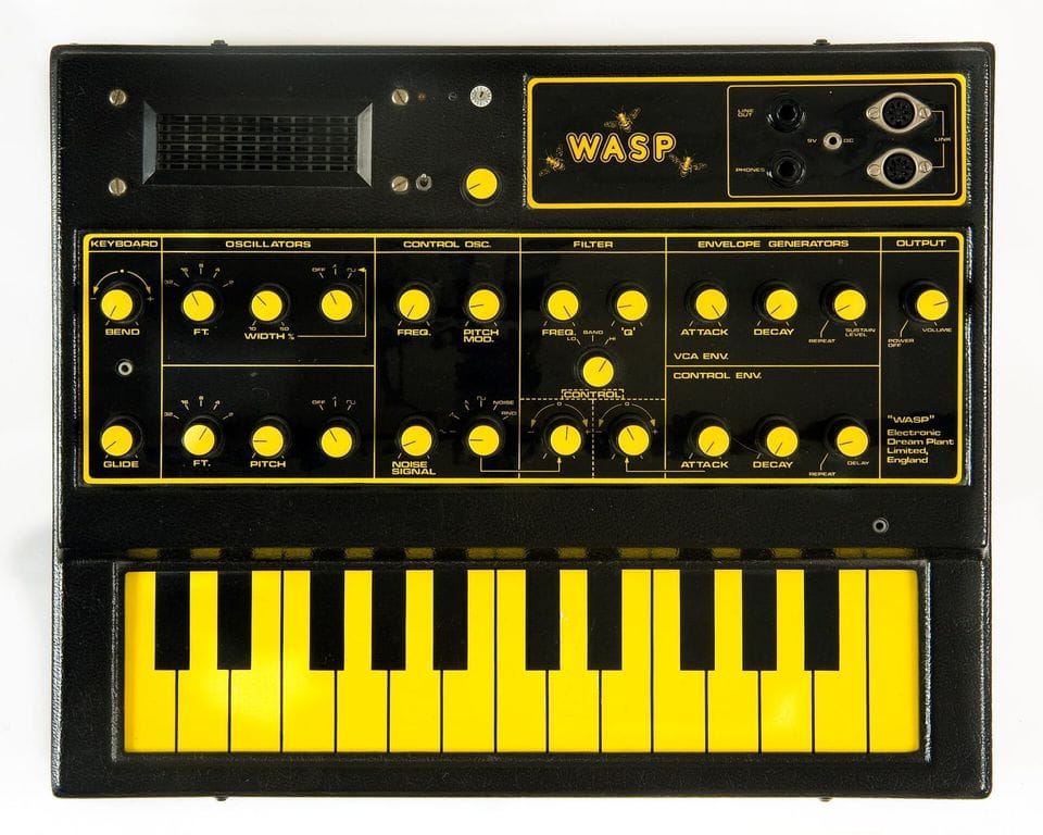 Sintetizador analógico amarillo y negro con teclado de dos tonos